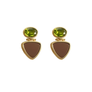 Detail of vintage gold earrings with green oval stone and brown triangle pendant