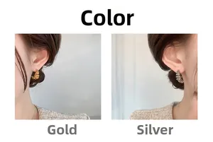 Close-up of gold and silver croissant earrings with spiral texture and metallic finish