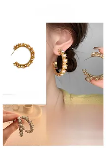 Détails des créoles dorées vintage avec perles blanches et sertis en forme de fleur