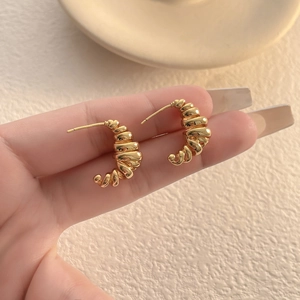 Irregular coiled gold C-shape stud earrings with a refined vintage croissant texture