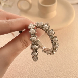 Gros plan de boucles d'oreilles vintage en argent avec perles blanches serties de fleurs