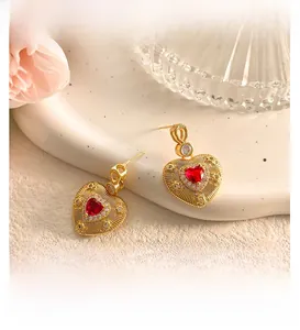 Macro detail of vintage gold heart earrings with red crystal and halo setting