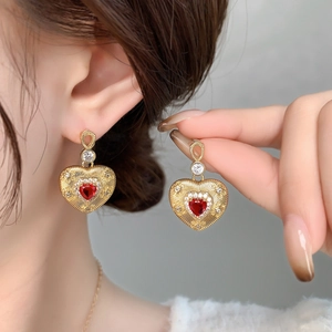 Detail of vintage 18K gold plated heart stud earrings with red crystal and diamonds
