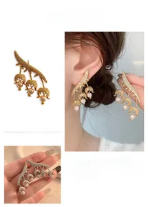 Detailed view of lily of the valley earrings with pavé zircons and dangling pearls