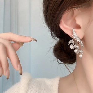 Elegant floral pearl drop earrings with zircon crystals in silver finish on model