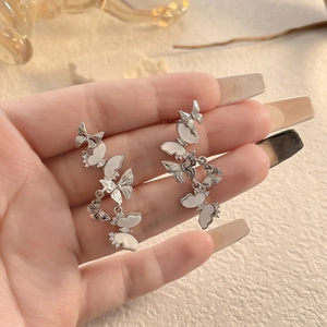 Dettaglio degli orecchini pendenti a farfalla in argento con madreperla e micro diamanti