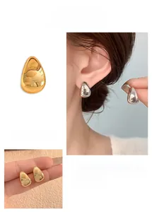Detailed views of minimalist teardrop earrings in polished gold and silver finishes