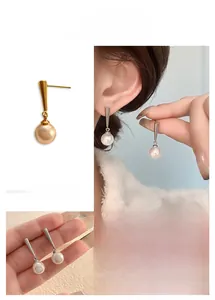 Macro detail of elegant 18K gold plated earrings with high-lustre round pearls
