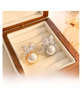 Macro shot of pearl flower earrings with marquise crystals in a beige jewelry box
