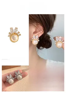 Detail of shell flower earrings with pearl and marquise zircon crown design in gold and silver
