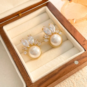 Close-up of pearl earrings with zircon crown setting in a wooden jewelry gift box