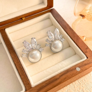 Detailed view of silver pearl earrings with marquise cubic zirconia in a jewelry box