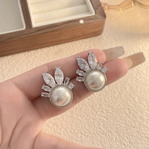 Macro view of shell flower earrings with large pearls and sparkling cubic zirconia stones
