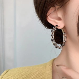 Orecchini a cerchio argento con stelle nere indossati da modella stile chic