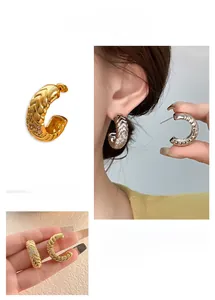 Detail of C-shaped woven earrings with micro-inlaid cubic zirconia in 18k gold plating