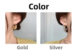 Close-up of C-shaped hoop earrings with V-pattern texture and zircons in gold and silver