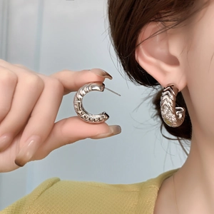 Silver-colored C-shaped hoop earrings with rippled texture and micro-paved zircons