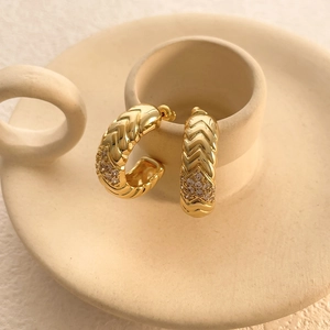 Macro detail of 18k gold plated chevron hoop earrings with micro-inlaid zircon accents