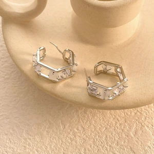 Detailed macro view of geometric hexagonal silver earrings with pavé set cubic zirconia