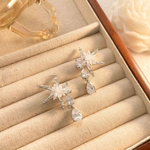 Détail de boucles d'oreilles tournesol de luxe plaquées or 18K avec zircons en poire