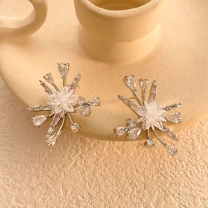 Vue macro des boucles d'oreilles tournesol avec zircons sur le bord d'une tasse