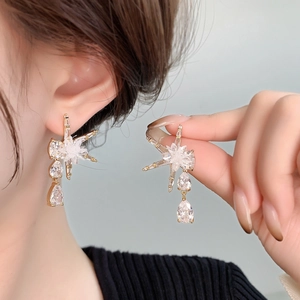 Détail de boucles d'oreilles fleur de soleil plaquées or 18 carats avec zircons scintillants