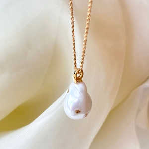 Détail du pendentif en perle baroque sur chaîne torsadée en or 18 carats sur soie