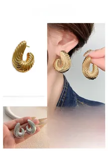 Dettaglio ravvicinato di orecchini a spirale a forma di C in finitura oro e argento