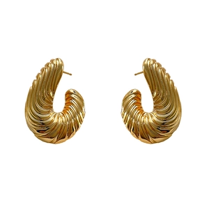 Orecchini a C dorati con texture astratta irregolare e dettagli metallici a onde