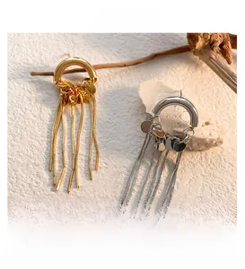 Detail of long snake chain tassel earrings with metallic sequins and 18k gold plating