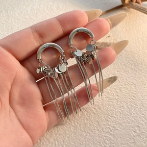 Detail of silver drop earrings with dangling fringe chains and sequin charms