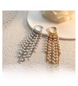 Vue détaillée des boucles d'oreilles longues à pampilles en perles dorées et argentées