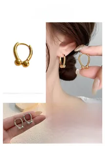 Close-up of U-shaped horseshoe earrings with metallic beads in gold and silver finish