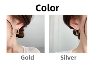 Detail view of U-shaped horseshoe earrings in polished gold and silver metallic finishes