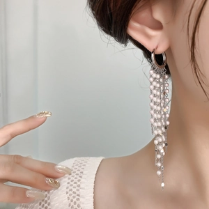 Élégantes boucles d'oreilles longues à pampilles en perles avec chaînes argentées sur modèle