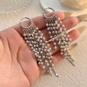 Détails de boucles d'oreilles pendantes en argent avec perles blanches et fines chaînes