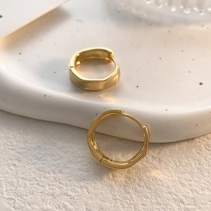 French style irregular gold geometric hoop earrings on a ceramic tray display
