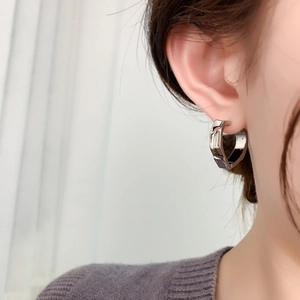 Macro side view of silver irregular geometric earrings with S925 hallmark on ear lobe