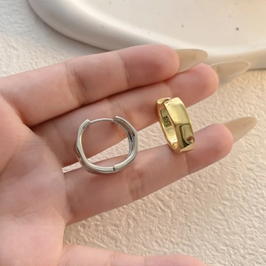Detailed macro view of minimalist geometric hoop earrings in polished gold and silver finishes