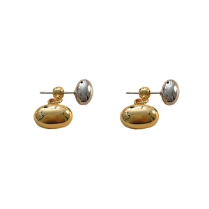 Macro detail of high-polish gold and silver contrast ball stud earrings in 18K plated copper