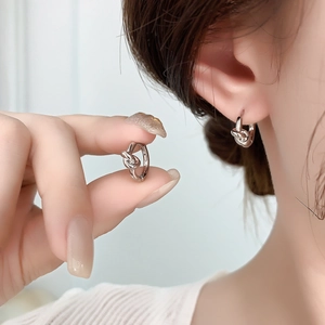Polished silver knot hoop earrings with a minimalist geometric twist design for women