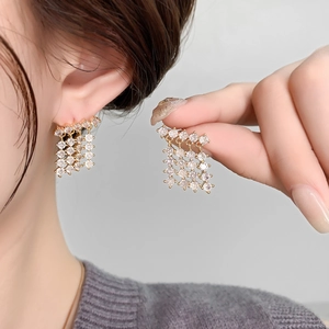 Sparkling zircon chandelier earrings in 18K gold plating worn by a model