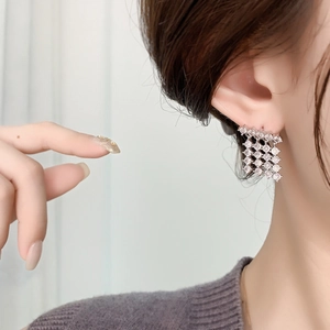 Sparkling diamond-set rhombus earrings in 18K gold plating shown on model ear