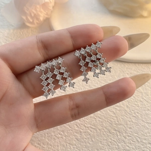 Close-up of silver tassel earrings with sparkling cubic zirconia in 18K gold plating