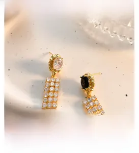 Detail of 18K gold-plated asymmetrical fringe earrings with black zircon stones