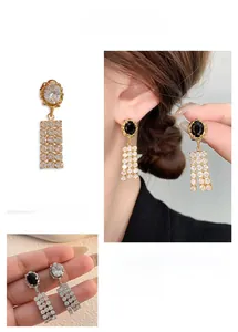 Detail of vintage palace style earrings with black zircon and gold chain tassels