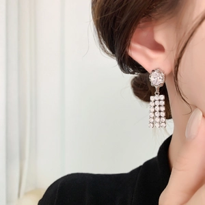 Silver fringe tassel earrings with zircon flower studs on a model for elegant look