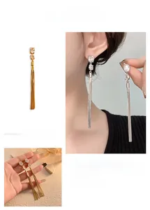 Macro detail of long tassel earrings with sparkling zircon stones in gold and silver
