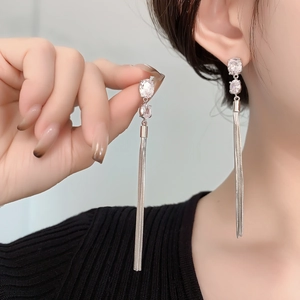 Elegant silver tassel drop earrings with zircon crystals shown on model ear
