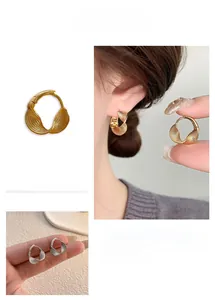 Detail view of woven twist design earrings with fine grid texture in gold and silver finish